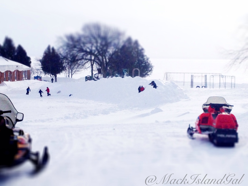 The kids of Mackinac Island Public School, enjoying their large wall of snow/snow hill